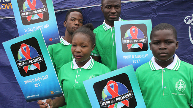 Young African students holding signs with "Keep the Promise" on them.